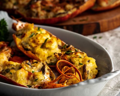 Lobster thermidor, classic lobster dish in which a cooked lobster is halved down middle. The meat is removed, chopped, and added to a creamy cheese sauce along with shallots, mushrooms, and sherry.